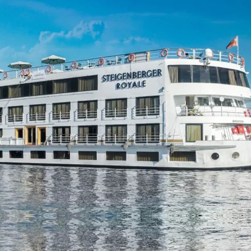 luxury white nile cruise ship sailing along calm nile waters surrounded by green palm trees and blue sky
