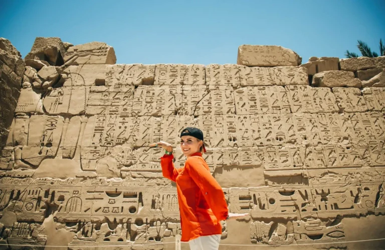 traveler exploring ancient temple columns in luxor before relaxing on red sea beaches during a 9 day egypt package
