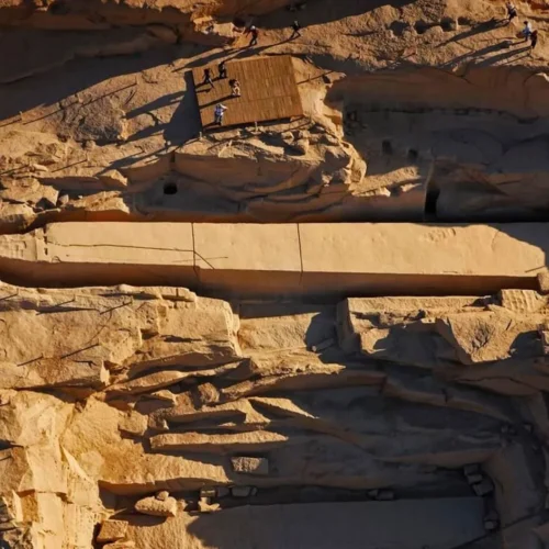 massive carved pink granite unfinished obelisk resting in an ancient pharaonic stone quarry in aswan