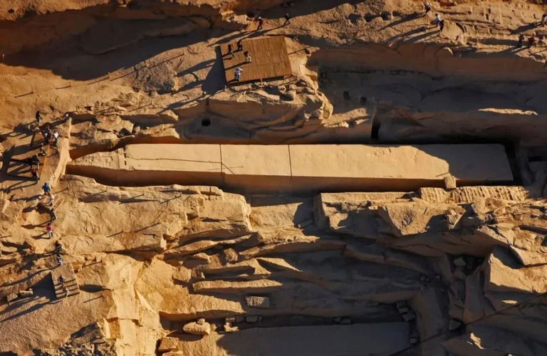 massive carved pink granite unfinished obelisk resting in an ancient pharaonic stone quarry in aswan