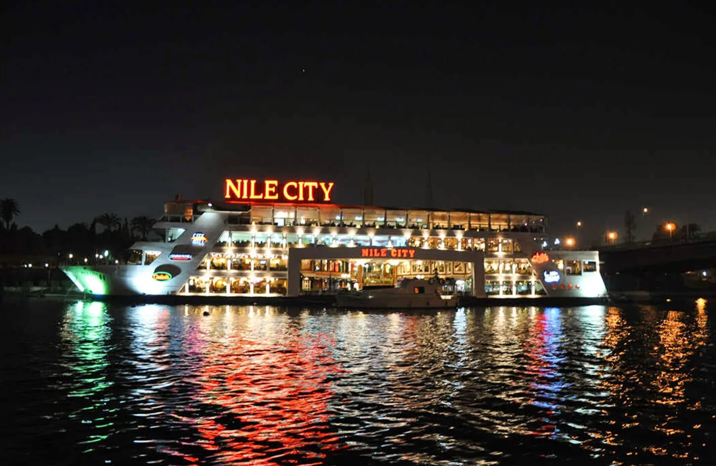 illuminated floating restaurant cruise ship sailing along the river nile in cairo at night during a dinner cruise