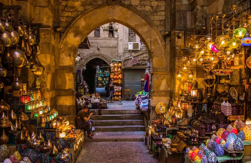 Lantern shops framing a stone archway in the Khan El Khalili bazaar