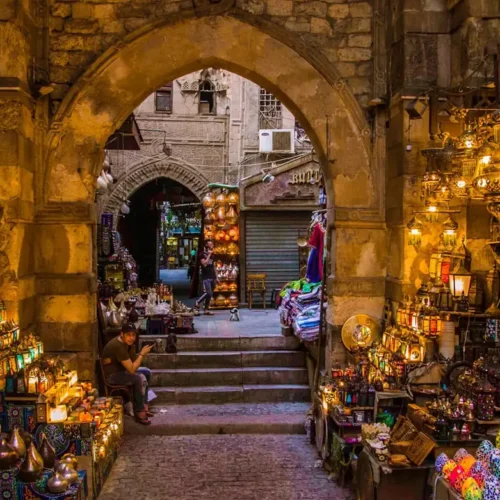 Lantern shops framing a stone archway in the Khan El Khalili bazaar