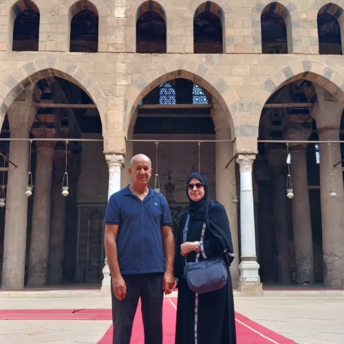 Couple standing in the arcaded courtyard of a historic Cairo mosque