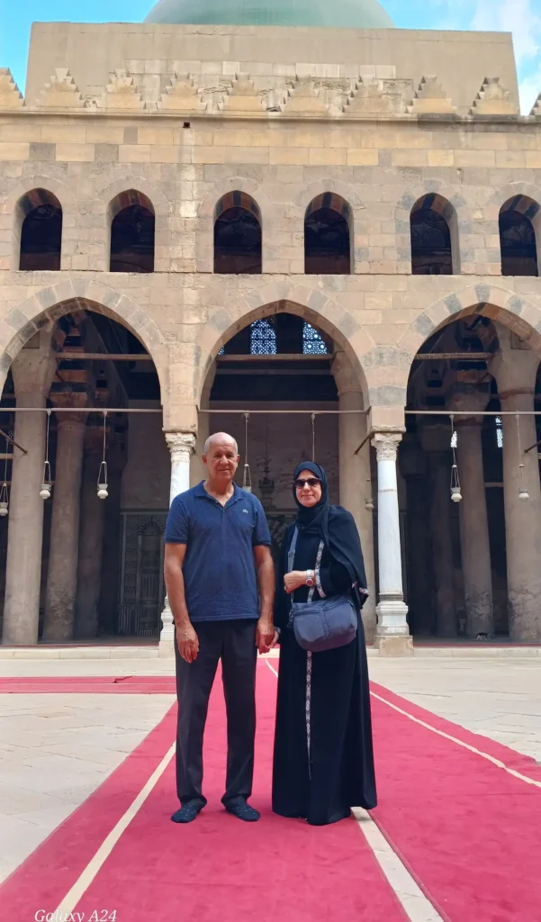 Couple standing in the arcaded courtyard of a historic Cairo mosque
