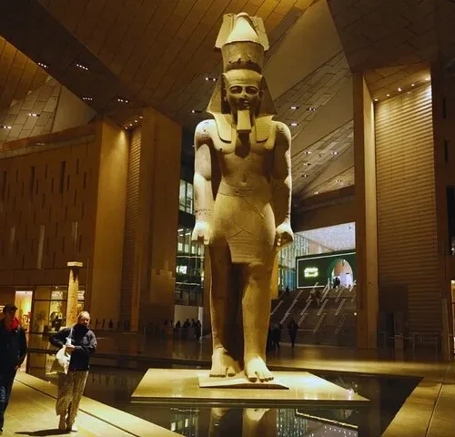 The colossal Ramses II statue lit in the Grand Hall of the Grand Egyptian Museum
