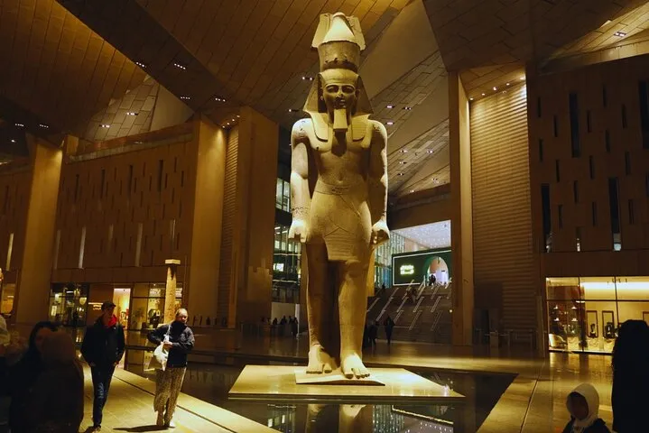 The colossal Ramses II statue lit in the Grand Hall of the Grand Egyptian Museum