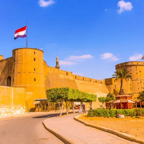 The outer defensive wall and round towers of the Saladin Citadel with the Egyptian flag
