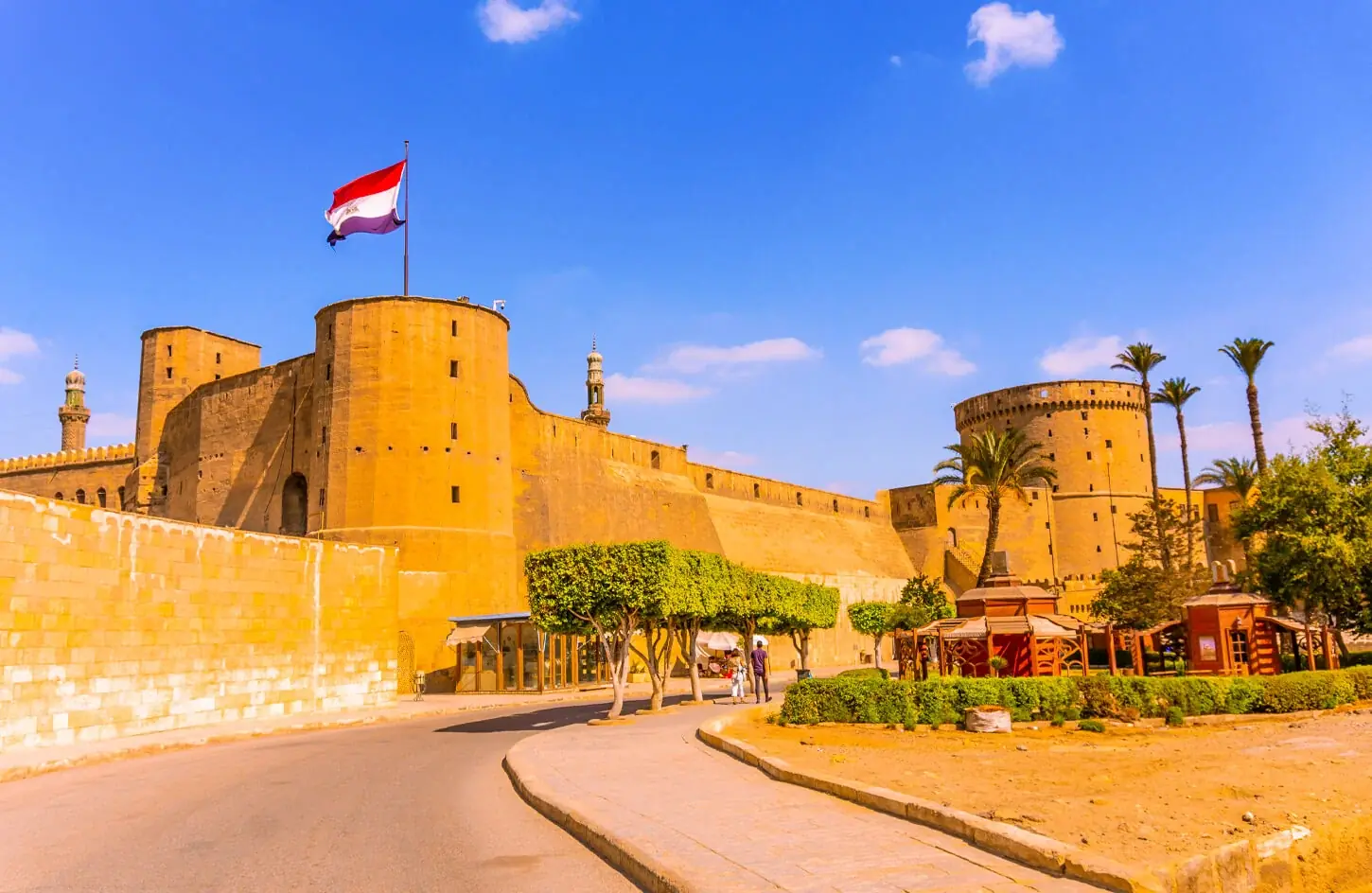 The outer defensive wall and round towers of the Saladin Citadel with the Egyptian flag