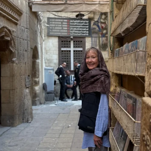 Traveler beside Coptic Cairo directional signs for the Hanging Church and museums