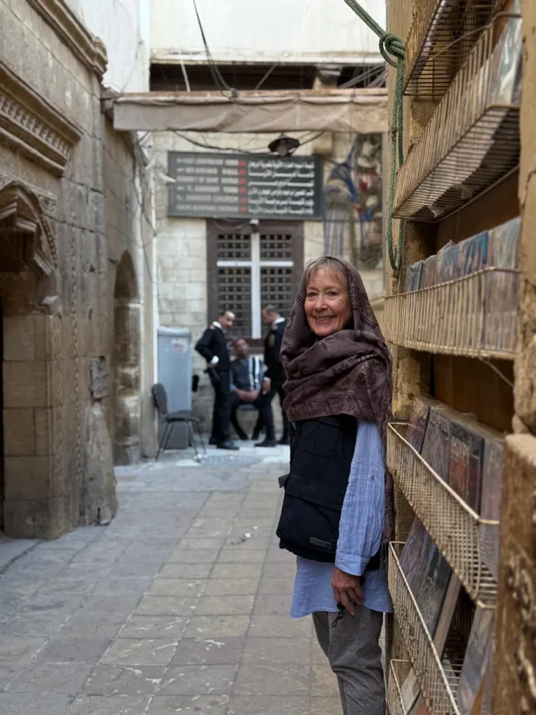 Traveler beside Coptic Cairo directional signs for the Hanging Church and museums