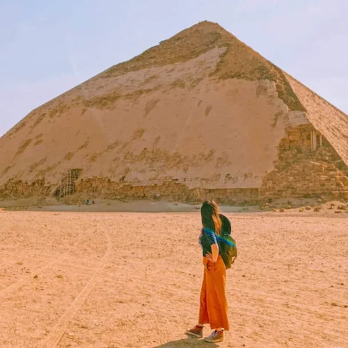 Girl gazing up at the Bent Pyramid across the open desert at Dahshur