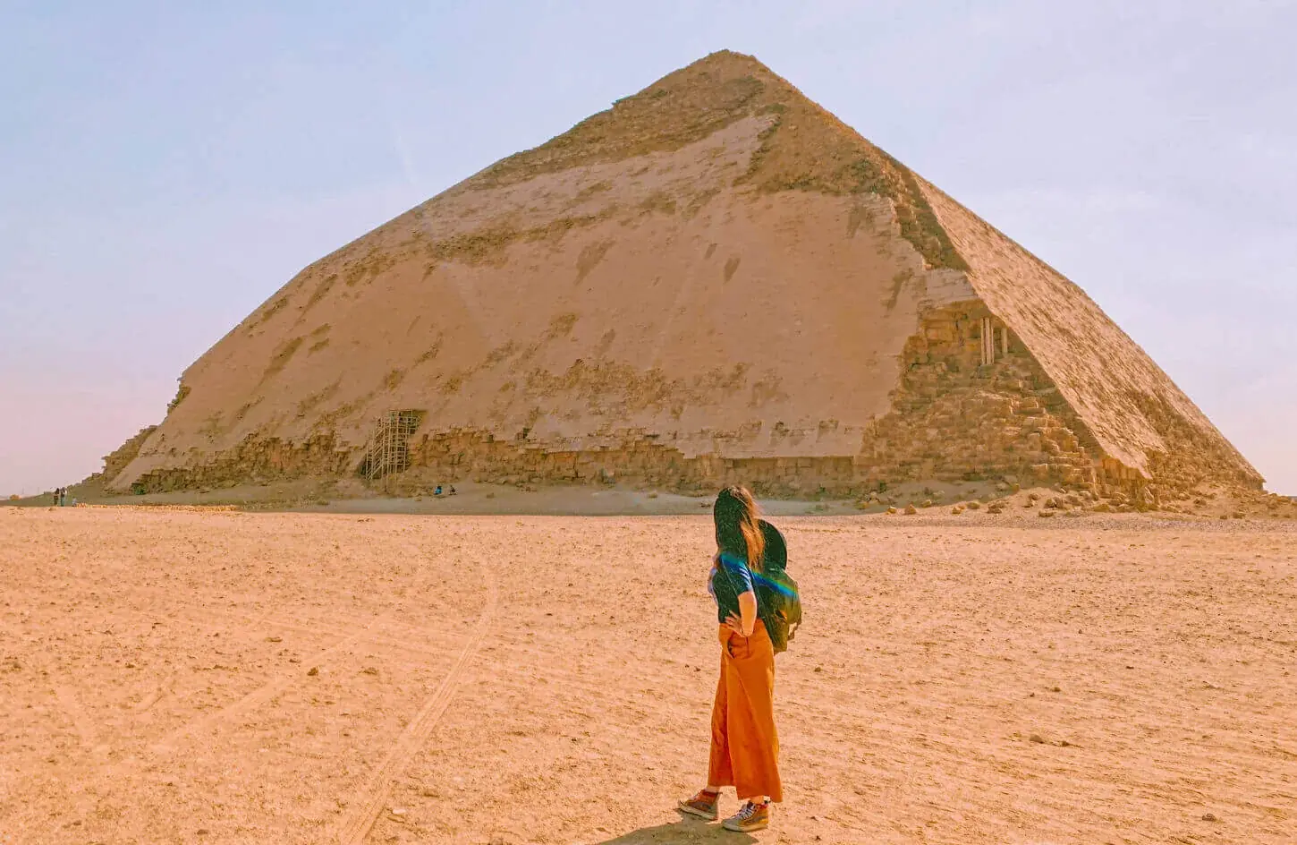 Girl gazing up at the Bent Pyramid across the open desert at Dahshur