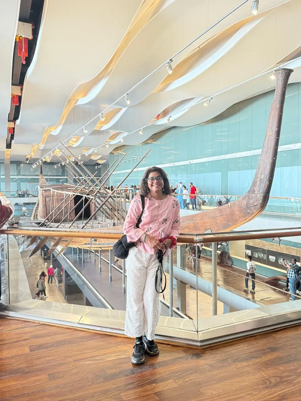 Traveler in the Khufu Solar Boat hall at the Grand Egyptian Museum