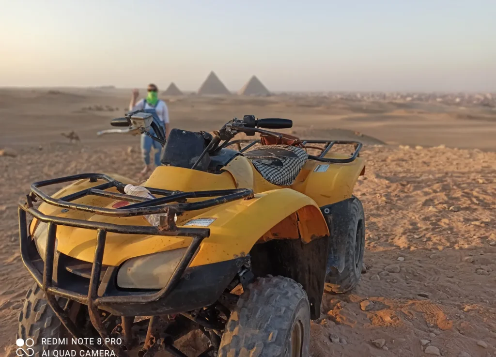 Yellow ATV on the Giza Plateau with a traveler waving at sunset