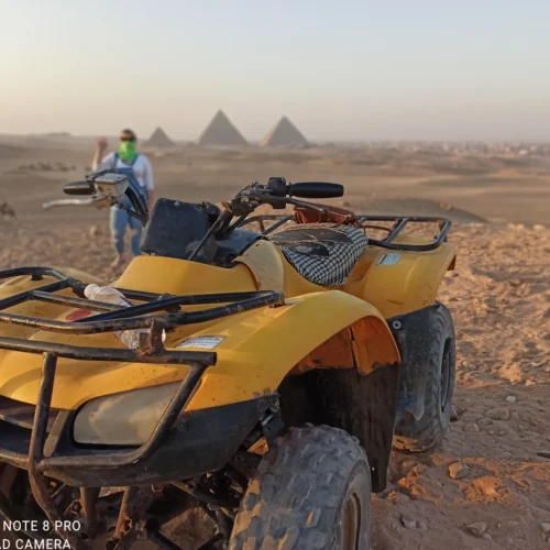 Yellow ATV on the Giza Plateau with a traveler waving at sunset