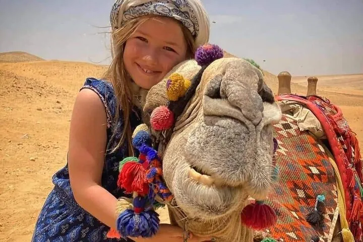 Traveler hugging a camel on the Giza desert plateau