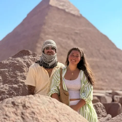 Couple, one wearing a keffiyeh scarf, in front of the Pyramid of Khafre
