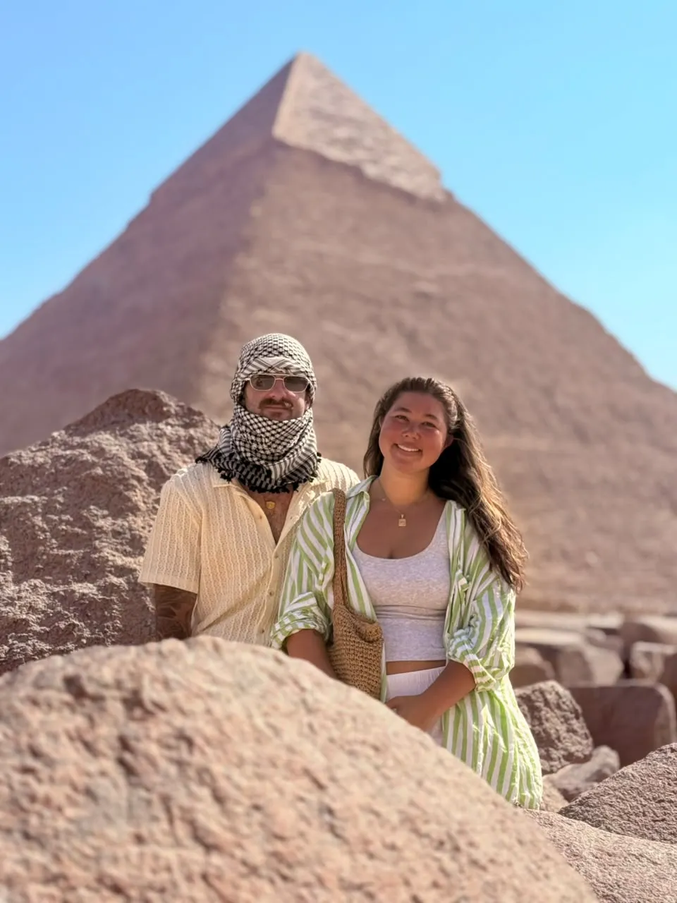 Couple, one wearing a keffiyeh scarf, in front of the Pyramid of Khafre