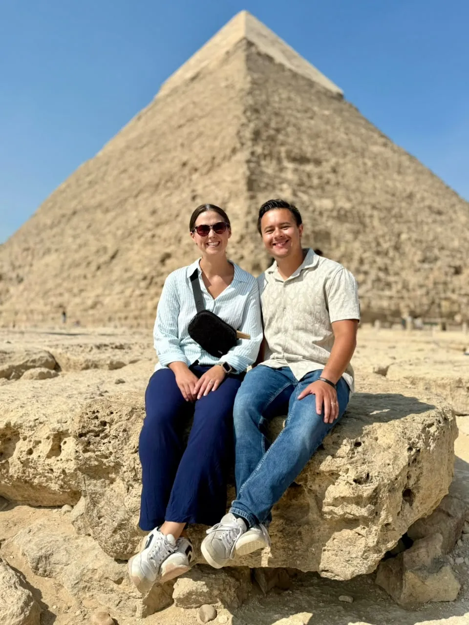 Couple seated on a rock in front of the Pyramid of Khafre at Giza