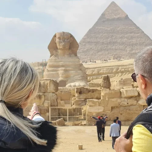 Couple gazing at the Great Sphinx and the Pyramid of Khafre at Giza