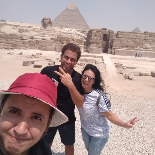Three friends taking a selfie with the Great Sphinx and pyramid behind