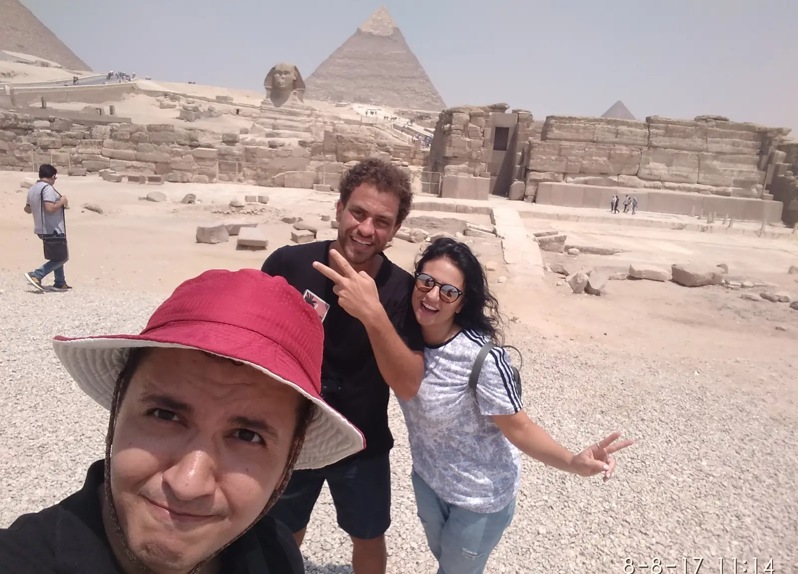 Three friends taking a selfie with the Great Sphinx and pyramid behind