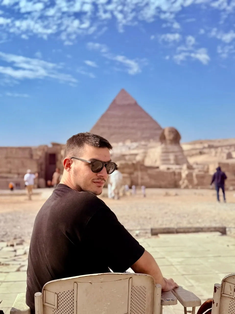 Traveler seated looking back toward the Great Pyramid and Sphinx at Giza