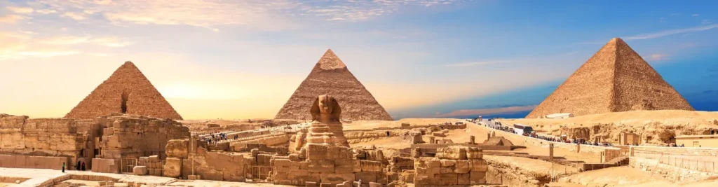 Panorama of the three Giza pyramids and the Great Sphinx under a golden sky