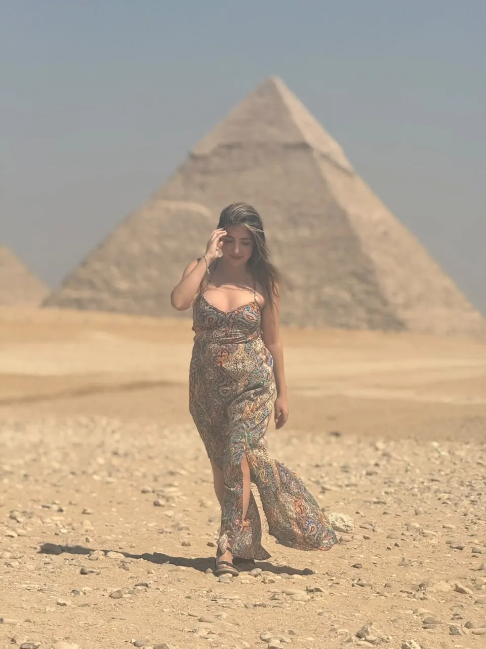 Traveler in a patterned dress walking before the Pyramid of Khafre
