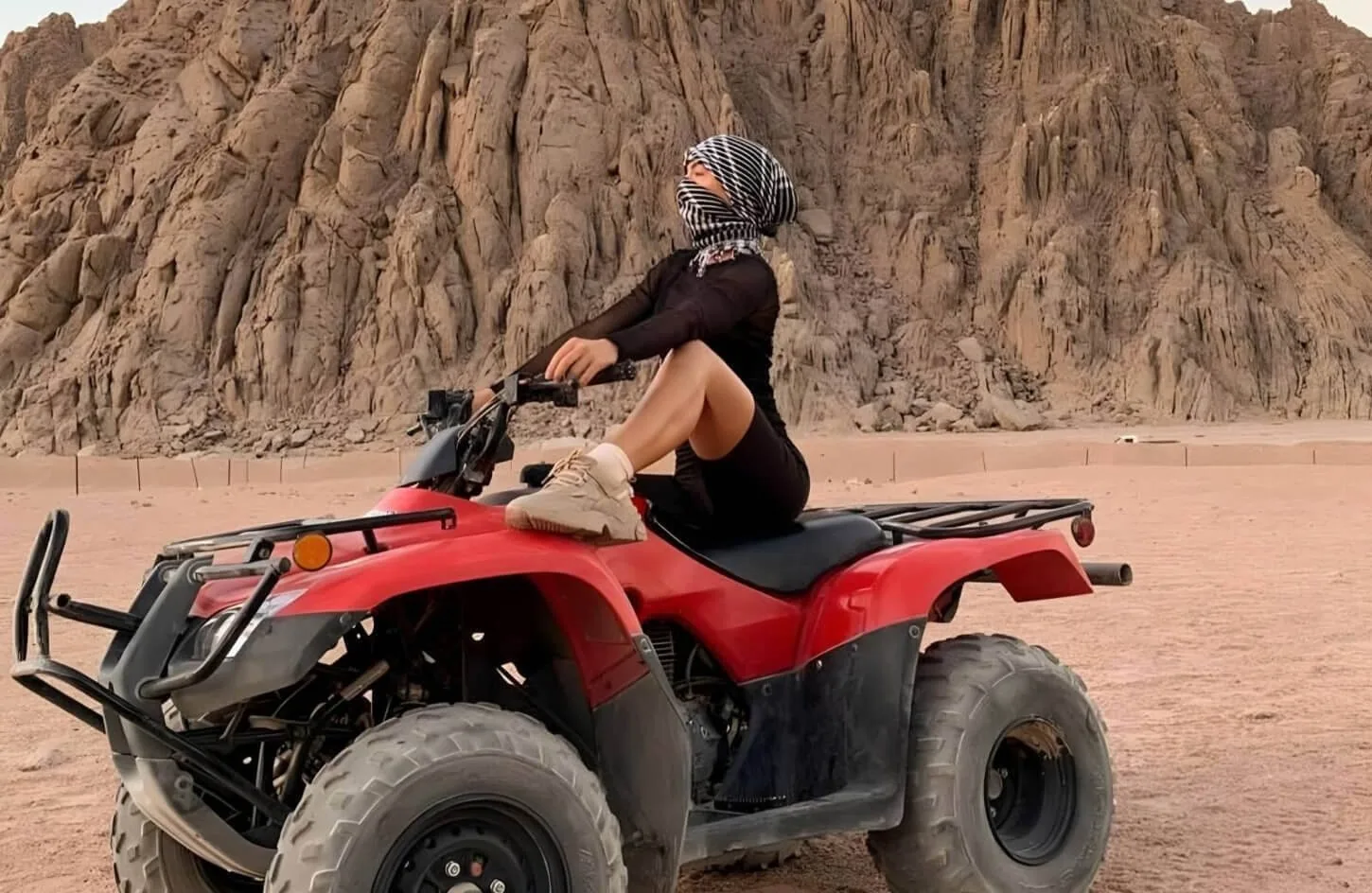 adventurous traveler riding a quad bike across red sea desert sands during a hurghada quad safari