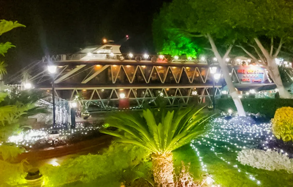 Illuminated Nile Crystal dinner cruise boat docked at night in Cairo