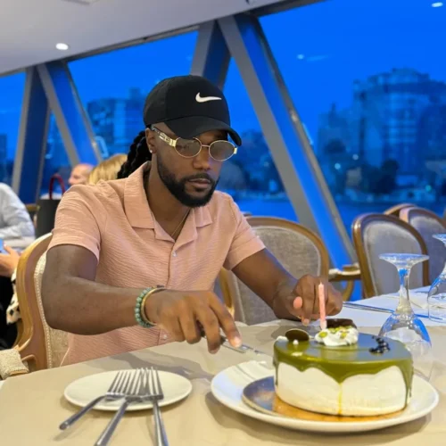 Traveler cutting a cake at a dinner table aboard a Nile cruise at twilight