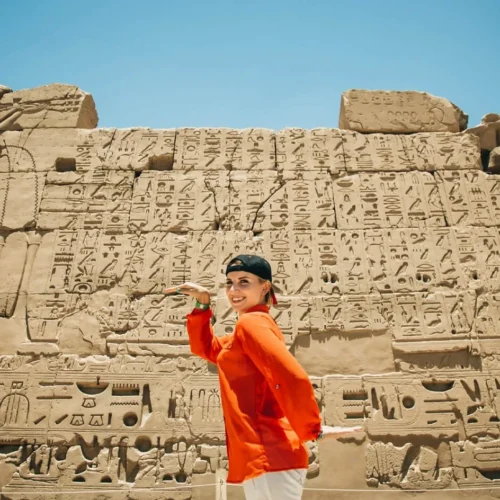 traveler admiring the ancient columns of luxor temple during an overnight guided tour from cairo