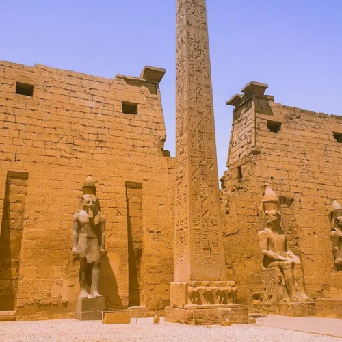 colossal seated statues of ramesses ii and towering obelisk at the entrance facade of luxor temple