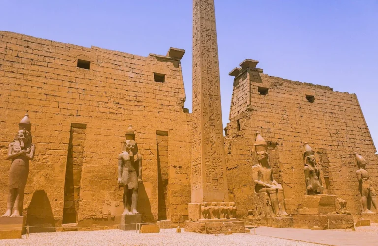 colossal seated statues of ramesses ii and towering obelisk at the entrance facade of luxor temple