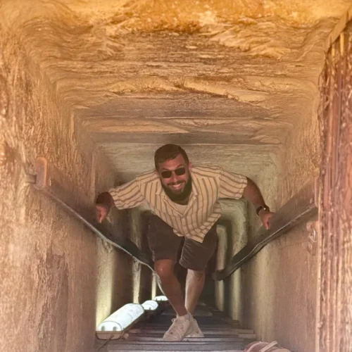 Traveler climbing the internal passage inside a Giza pyramid