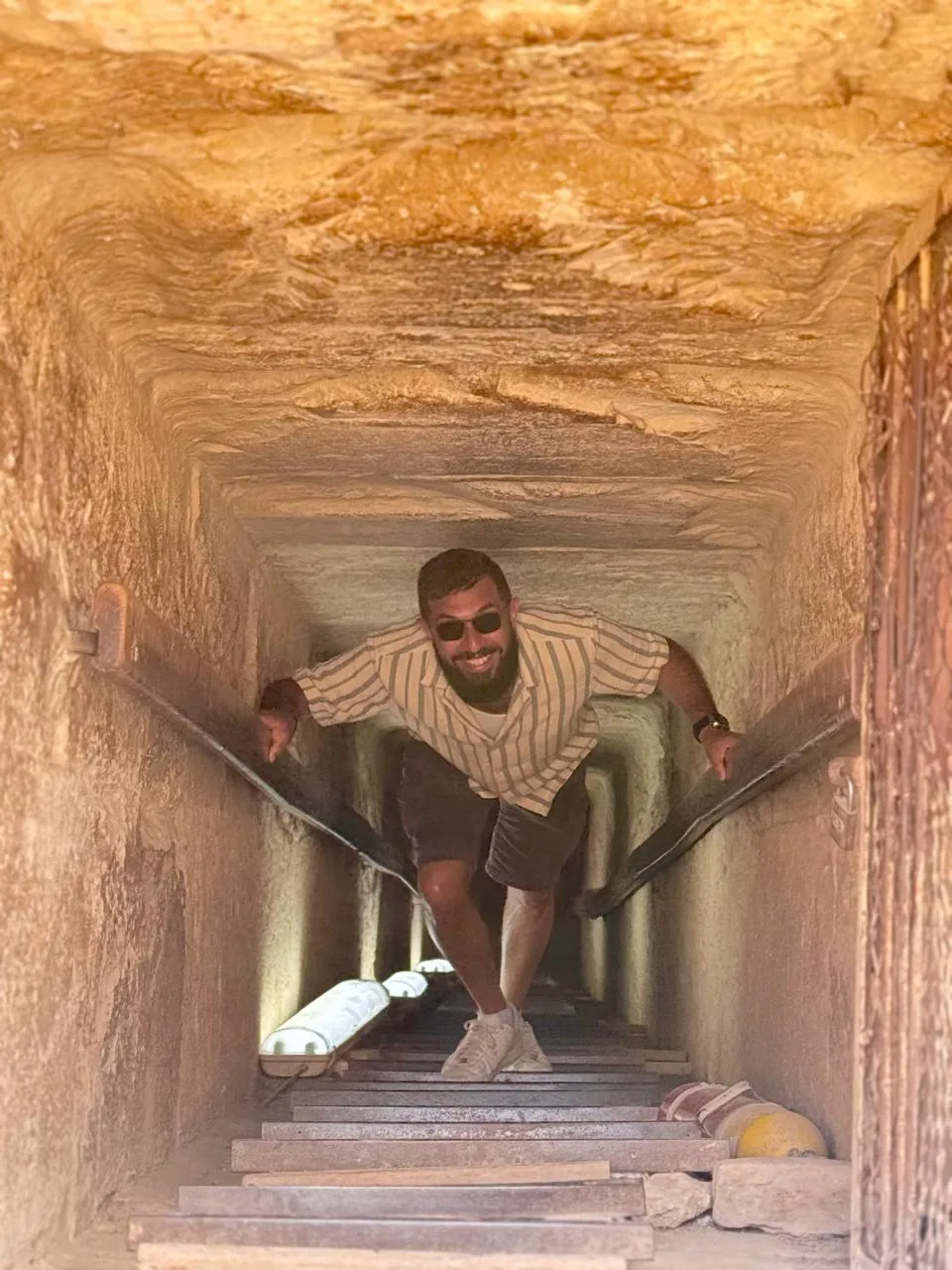 Traveler climbing the internal passage inside a Giza pyramid