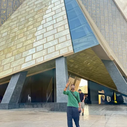 Traveler at the pyramid-shaped entrance of the Grand Egyptian Museum