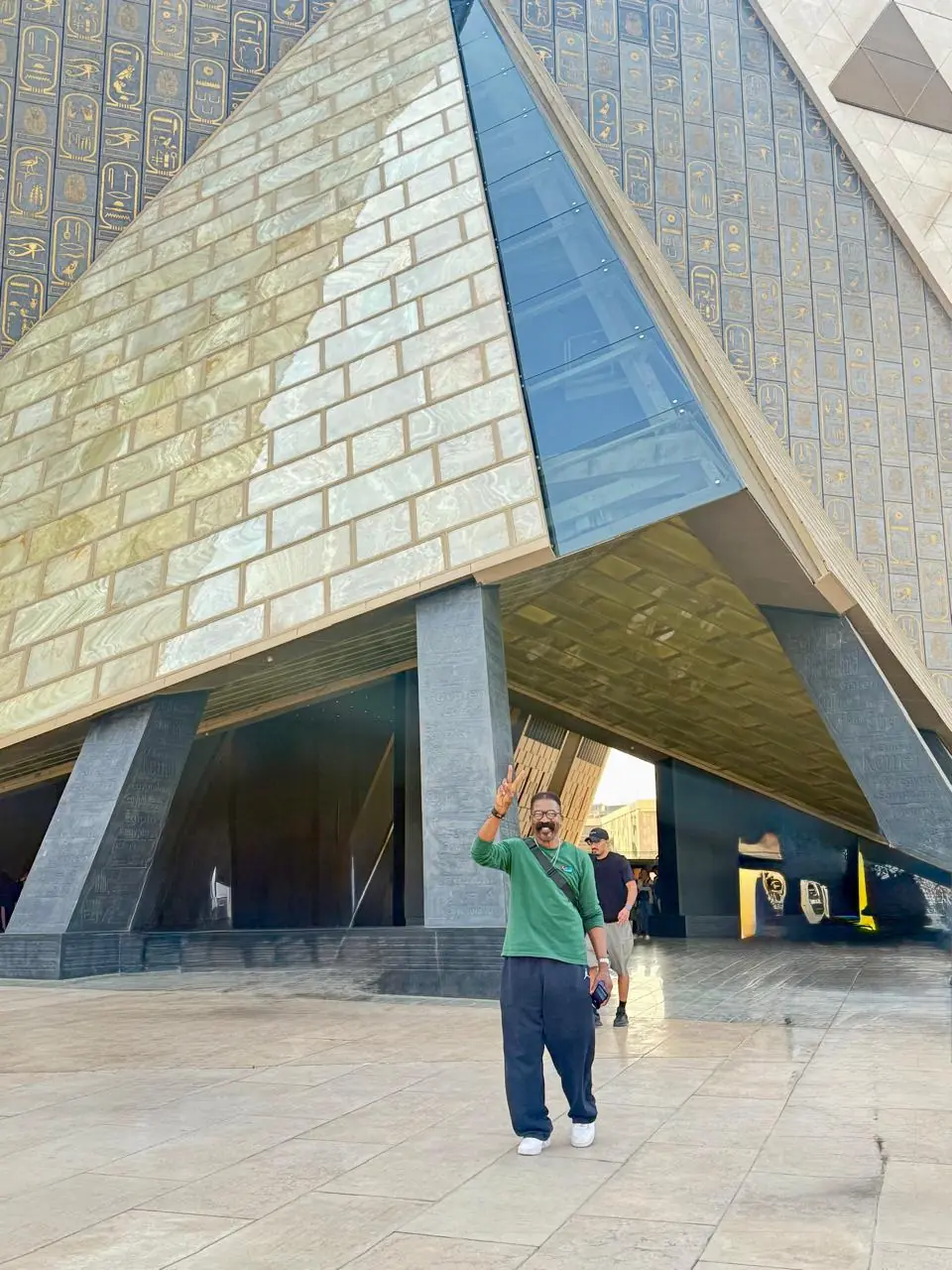 Traveler at the pyramid-shaped entrance of the Grand Egyptian Museum