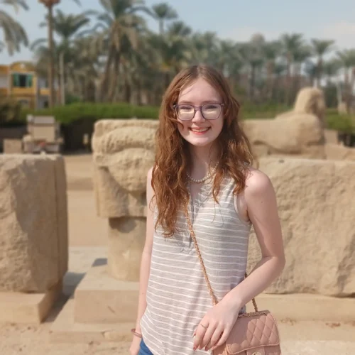 Traveler at the open-air site of ancient Memphis with palm trees