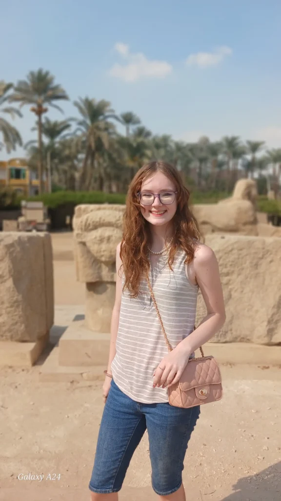 Traveler at the open-air site of ancient Memphis with palm trees