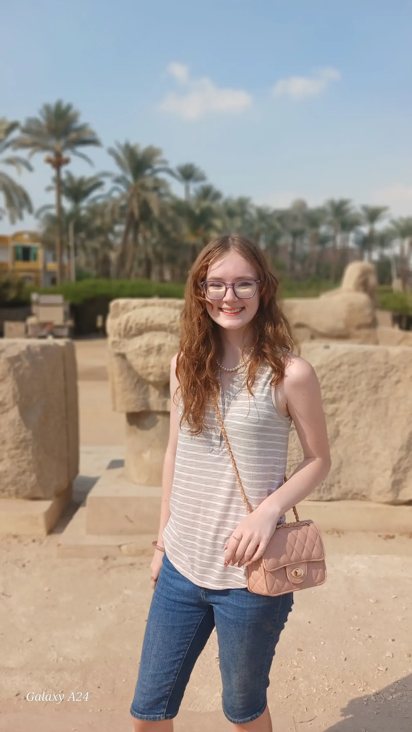 Traveler at the open-air site of ancient Memphis with palm trees