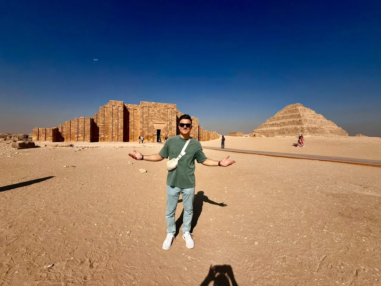 Man with open arms before the Djoser funerary complex and Step Pyramid at Saqqara