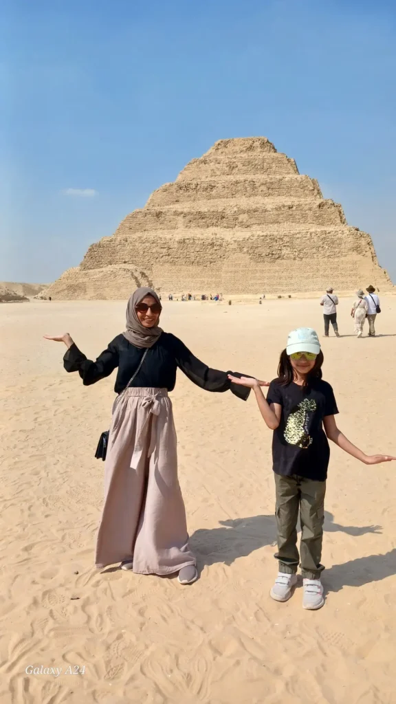 Mother and child posing in front of the Step Pyramid of Djoser at Saqqara