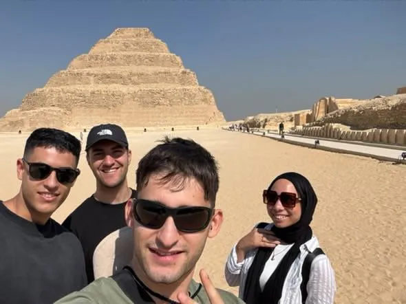 Group of friends taking a selfie on the causeway to the Step Pyramid at Saqqara