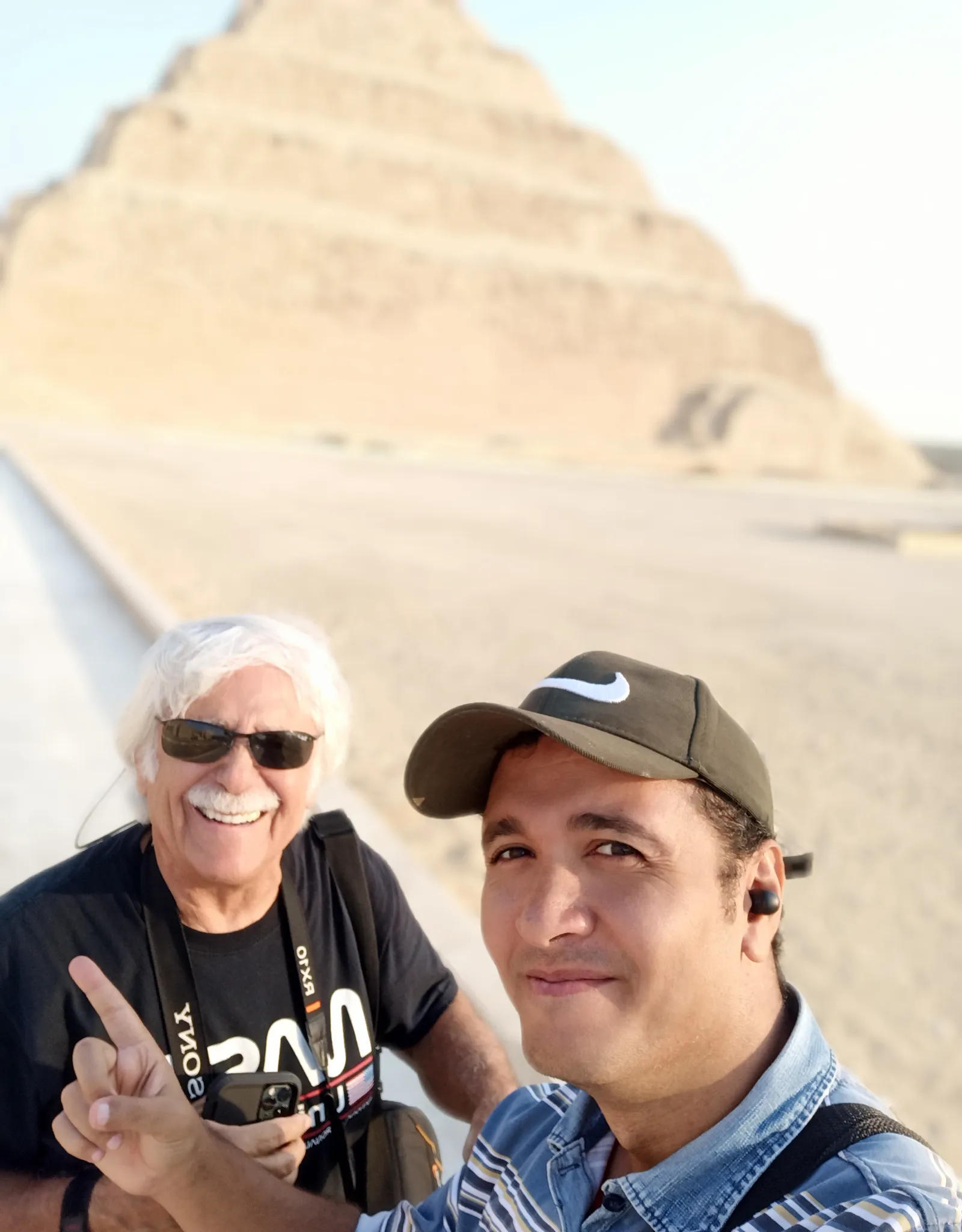 Two men taking a selfie in front of the Step Pyramid of Djoser at Saqqara