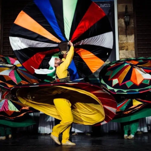 whirling dervish dancer wearing a colorful spinning skirt performing traditional tanoura sufi dance at wekalet el ghouri cairo