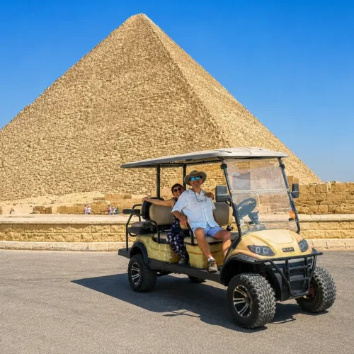 Couple in a golf cart in front of the Great Pyramid of Khufu at Giza