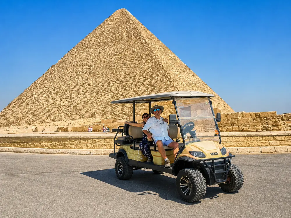 Couple in a golf cart in front of the Great Pyramid of Khufu at Giza